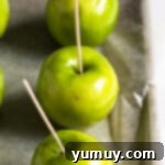 Inserting kebab sticks into apples, preparing them for caramel.