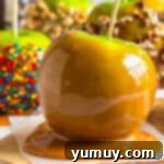 Hardened caramel apples on a baking sheet, ready to be enjoyed.